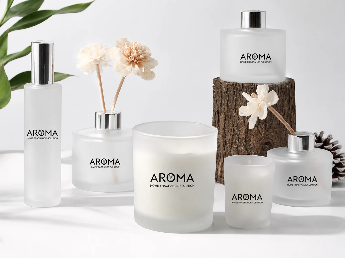 Glass containers for different product lines including room spray bottles, reed diffuser bottles, and candle jars in a coordinated frosted white collection