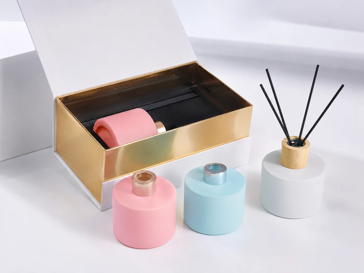 Coordinated gift box with custom insert holding a diffuser bottle and candle jar for branded packaging presentation