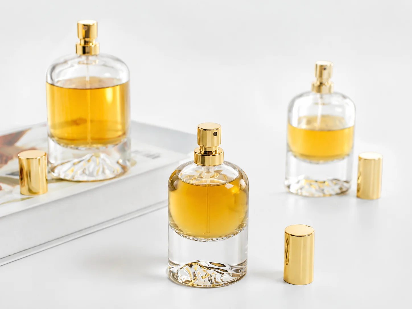 Clear glass perfume bottles with golden fragrance and gold sprayers for custom perfume packaging