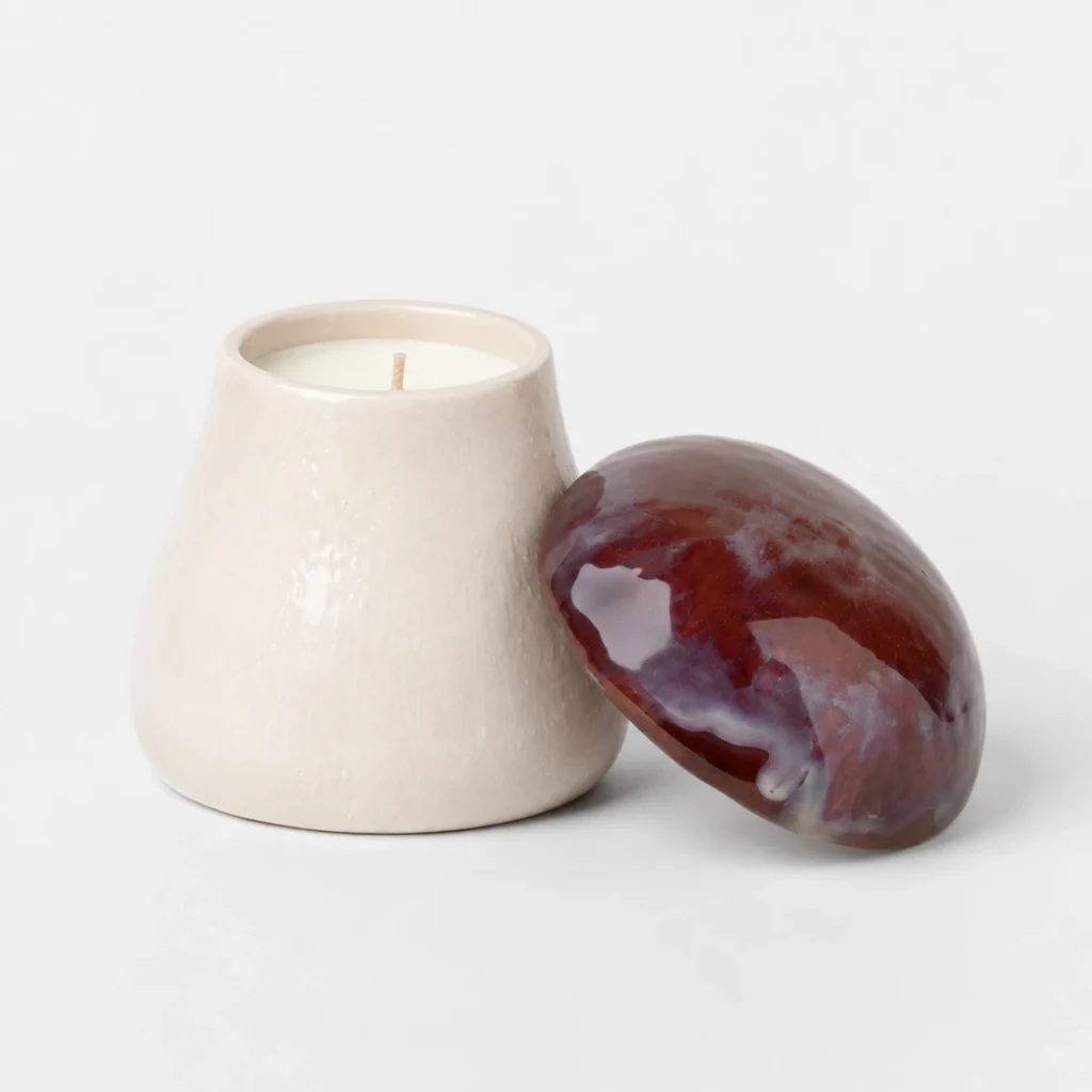 Mushroom-shaped ceramic candle jar with white wax and marbled lid detail