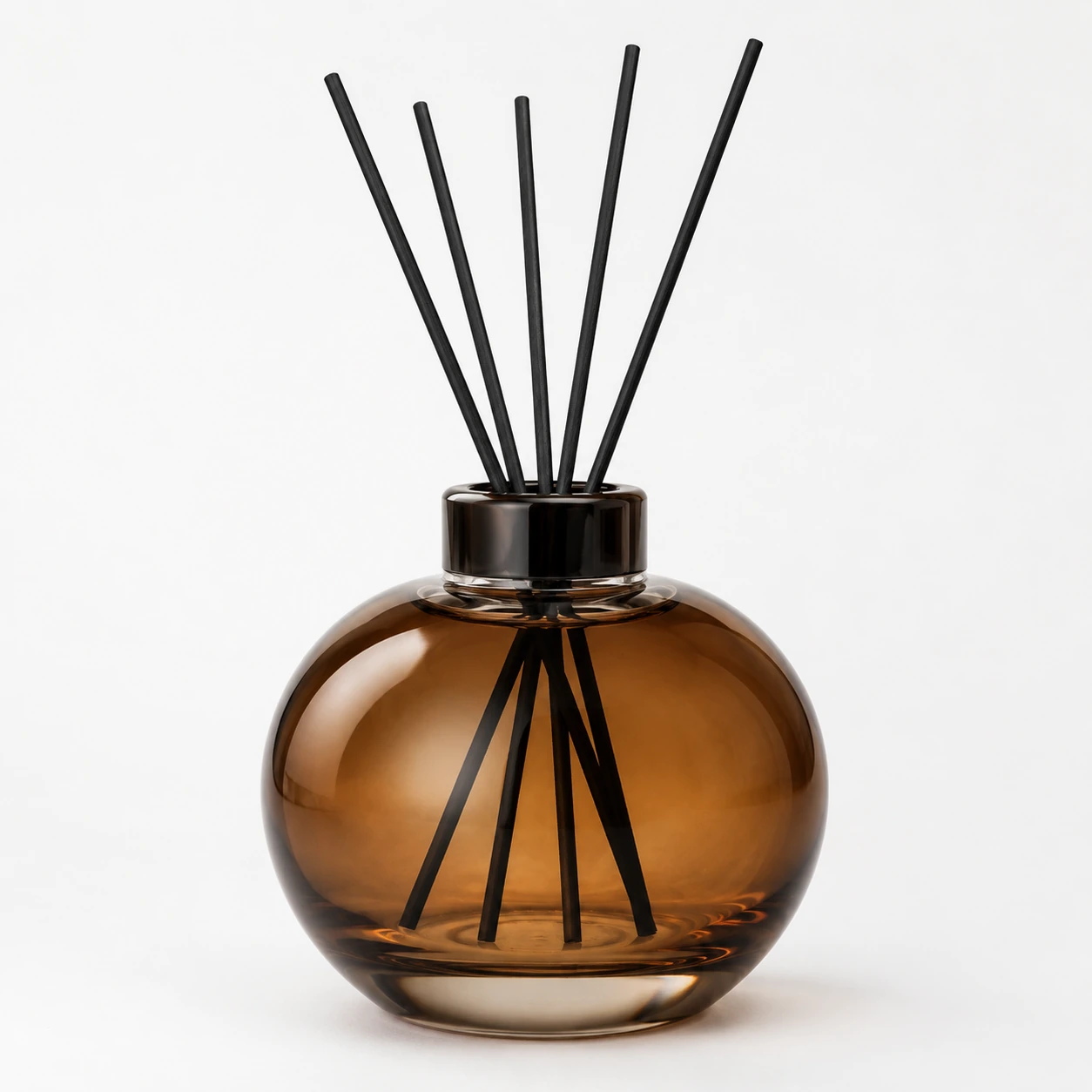Amber round glass reed diffuser bottle with dark collar and black reeds