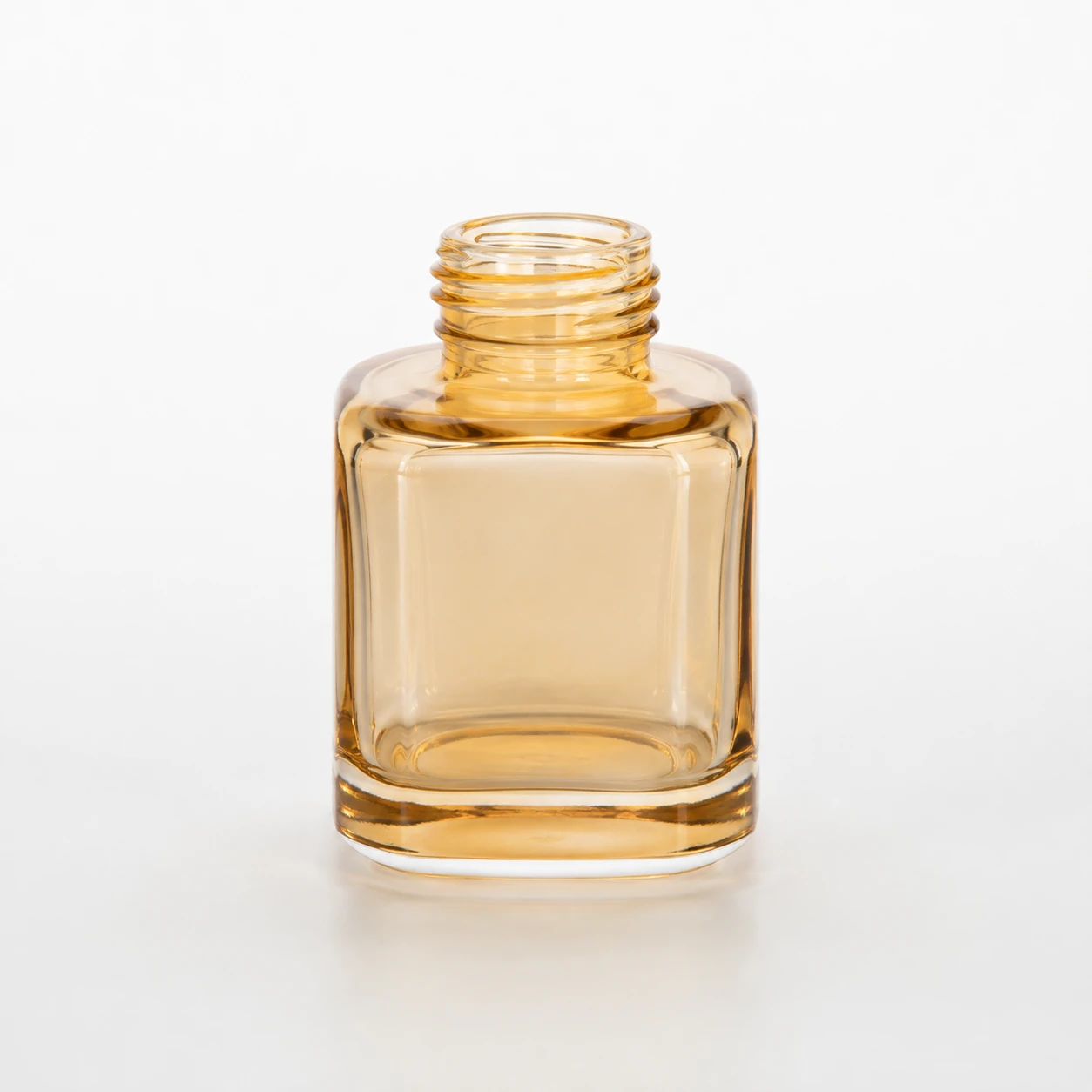 Amber rounded-square glass diffuser bottle with a thick glass base