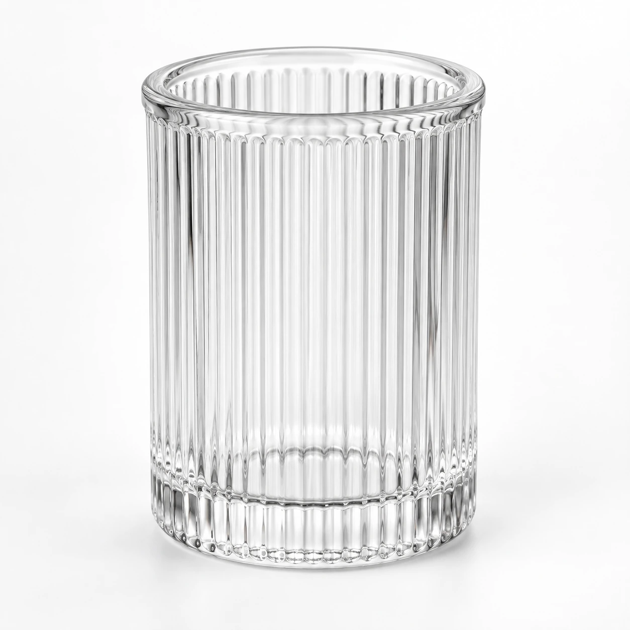 Clear glass toothbrush holder with vertical ribbed texture on a clean white studio background.
