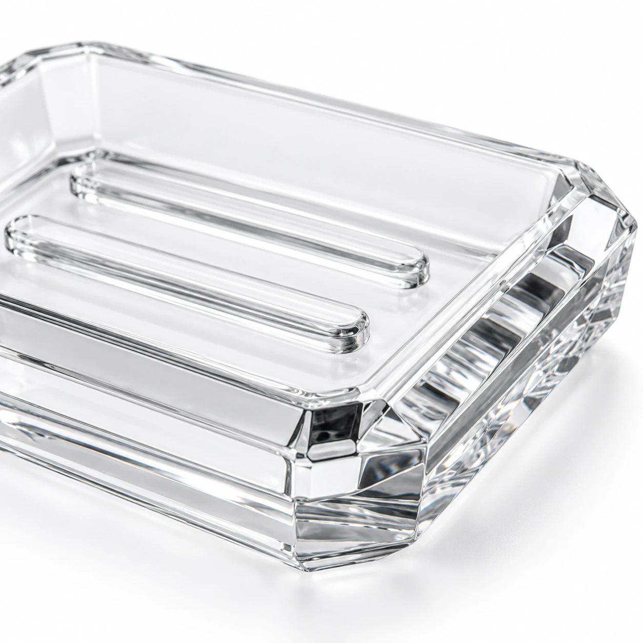 Clear glass soap dish with a rectangular faceted design on a clean white studio background.