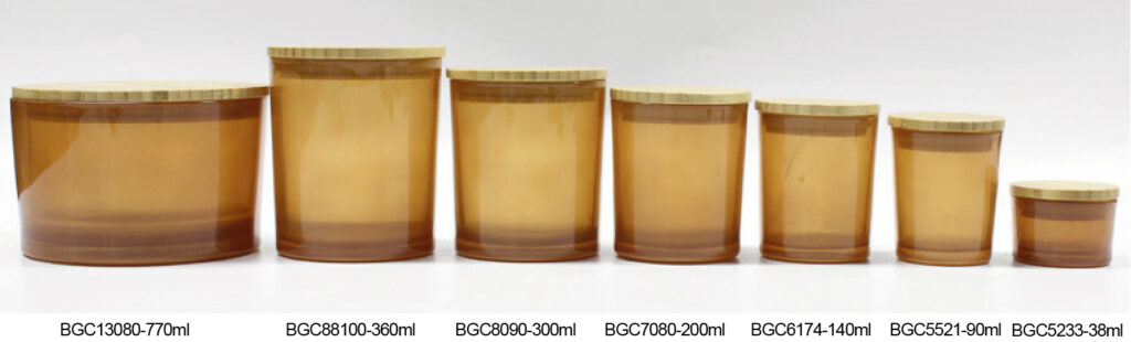 Amber, red and green translucent cylindrical vessels in a row.