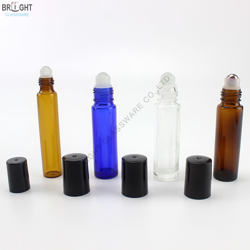 Amber, blue and clear glass roll-on bottles with black caps removed