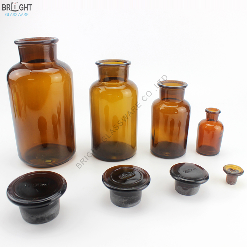 Four amber glass bottles with separate glass stoppers
