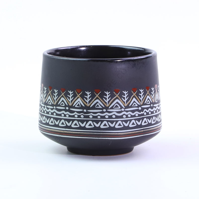 Dark ceramic candle vessel with a decorative geometric pattern Dark round vessel with patterned decorative bands around its lower body.