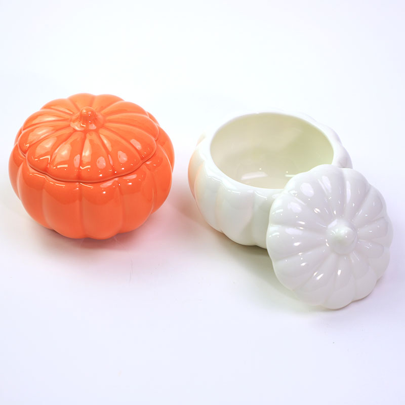 Orange and white pumpkin-shaped ceramic candle jars