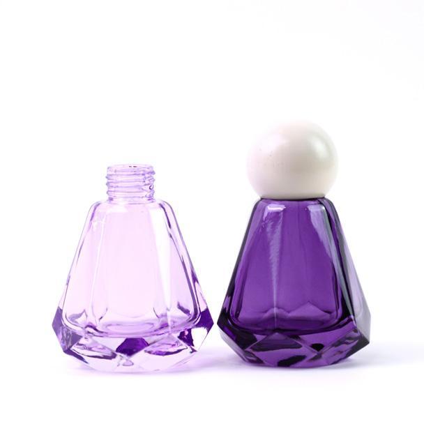 Purple diffuser bottle beside matching rounded cap assembly Purple diffuser bottle beside matching rounded cap assembly
