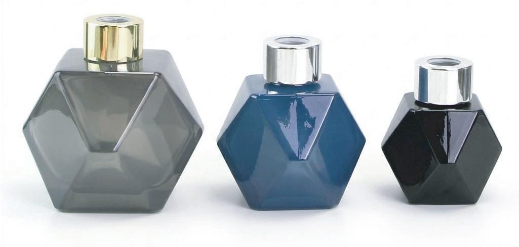 Three faceted glass diffuser bottles with metallic-colored caps Three faceted glass diffuser bottles with metallic-colored caps
