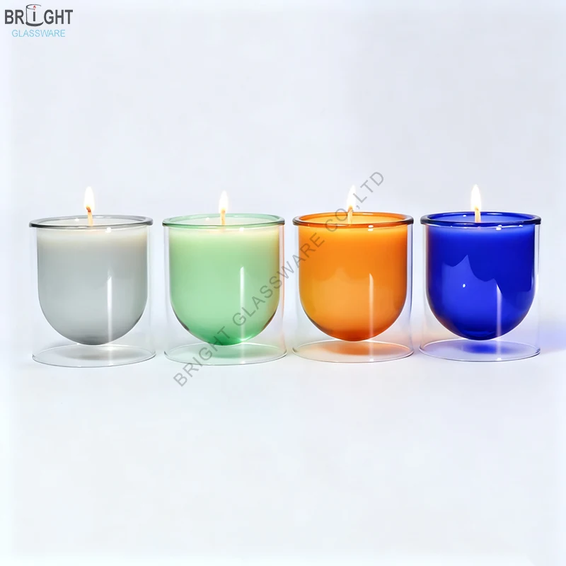 Colored double-wall borosilicate glass candle jars in gray green orange and blue with lit candles