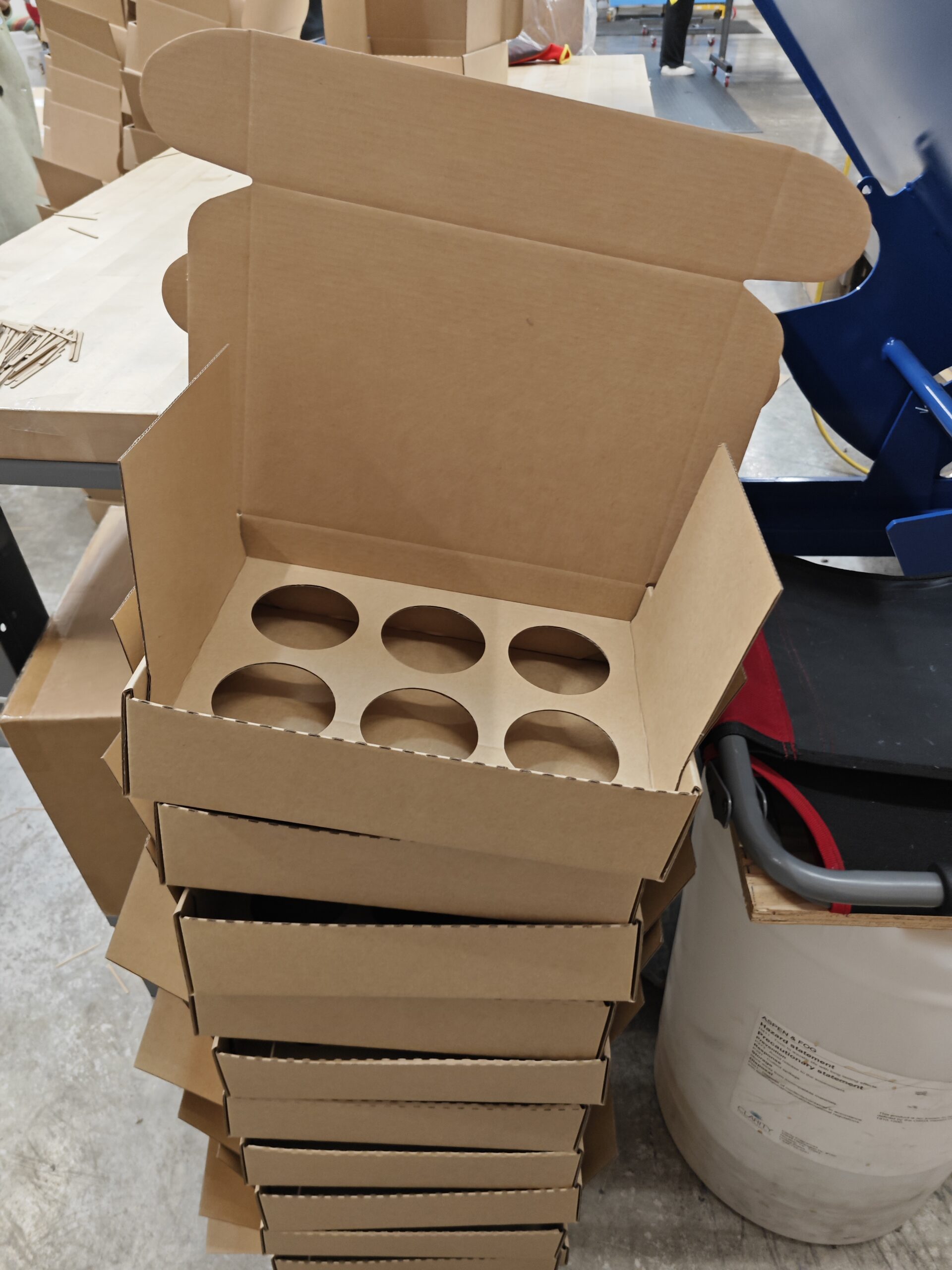 Stacked brown boxes with circular openings cut into the top insert.
