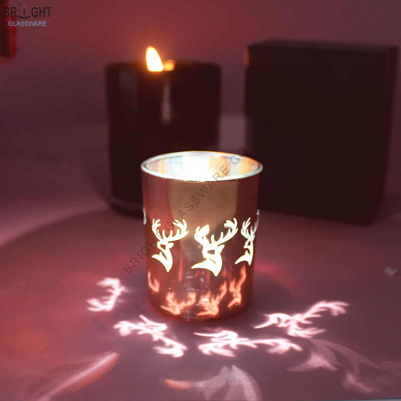 Glass candle holder with illuminated stag motifs and projected patterns