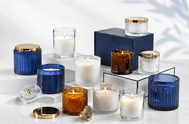 Custom candle jars in clear, blue and amber glass with lids and branded packaging