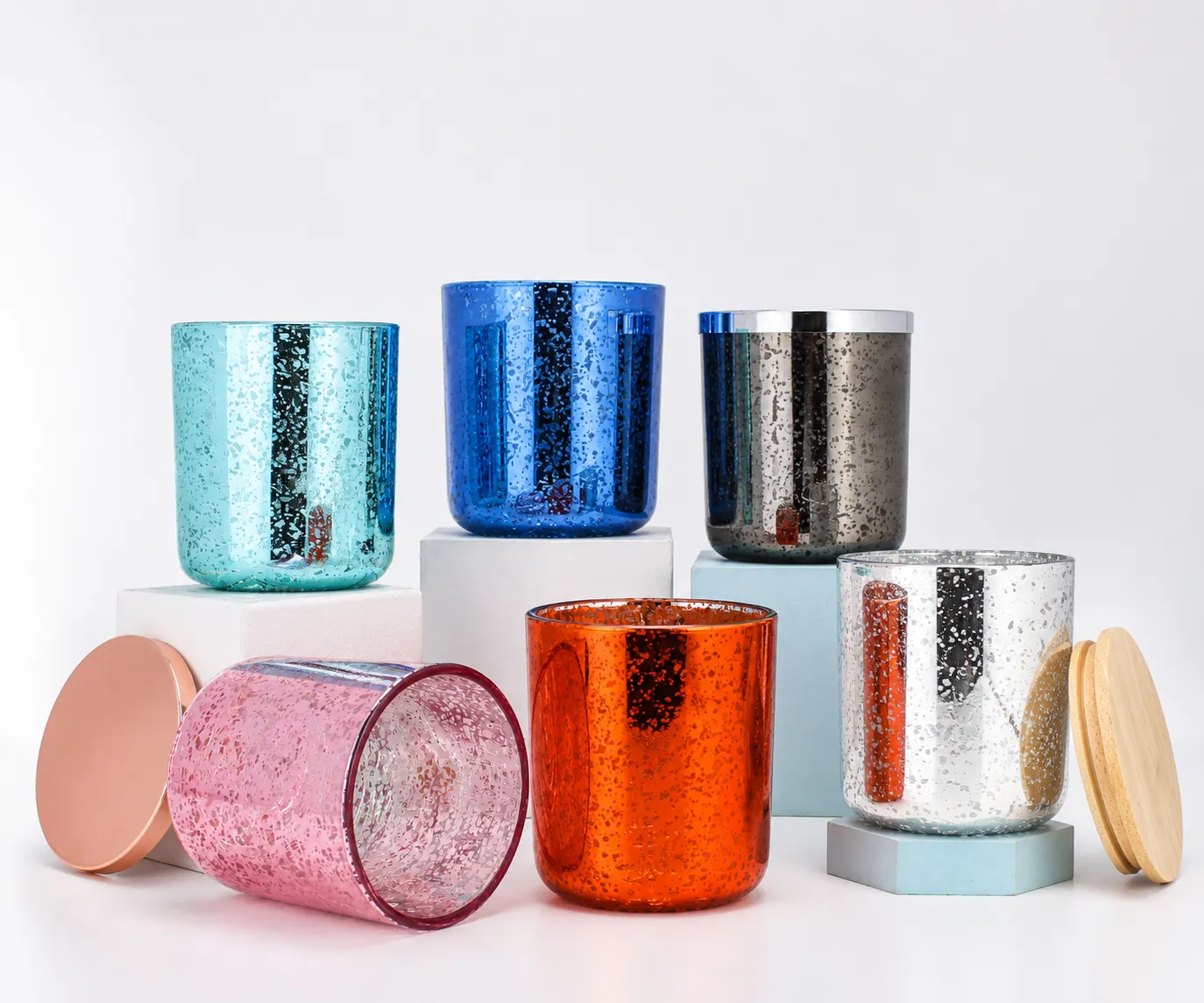 Decorated glass candle jars in blue, silver, orange and pink finishes with matching lid options for surface finish validation