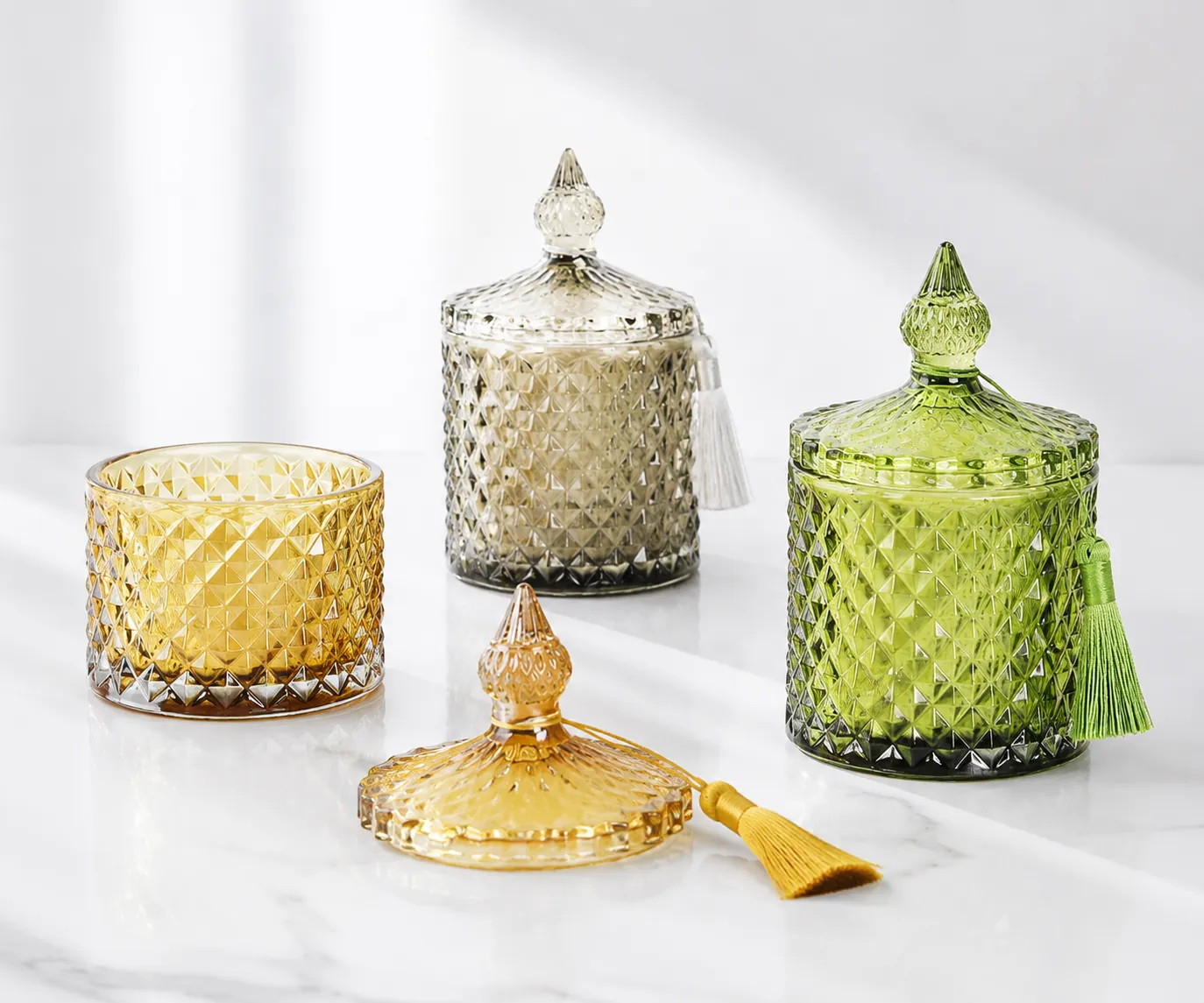 Decorative faceted glass candle jars with lids in amber, clear and green finishes for candle packaging sampling