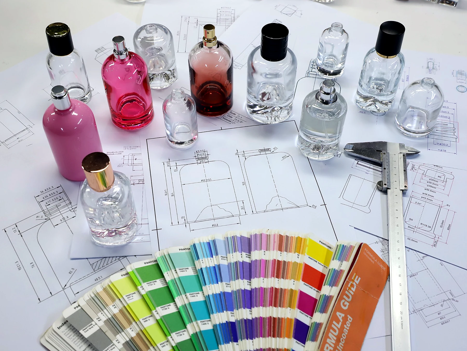 Color-coated and spray-finished perfume bottles in pink, amber, clear and white with Pantone color swatches and technical drawings