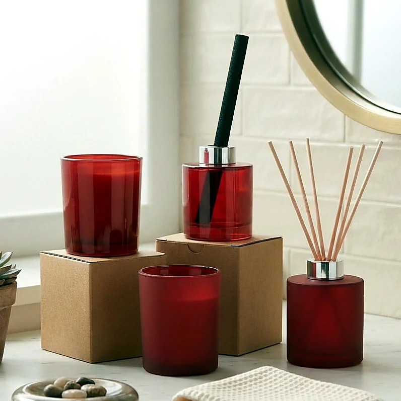 Red frosted candle jar and diffuser bottle set showing matte color coating for home fragrance packaging